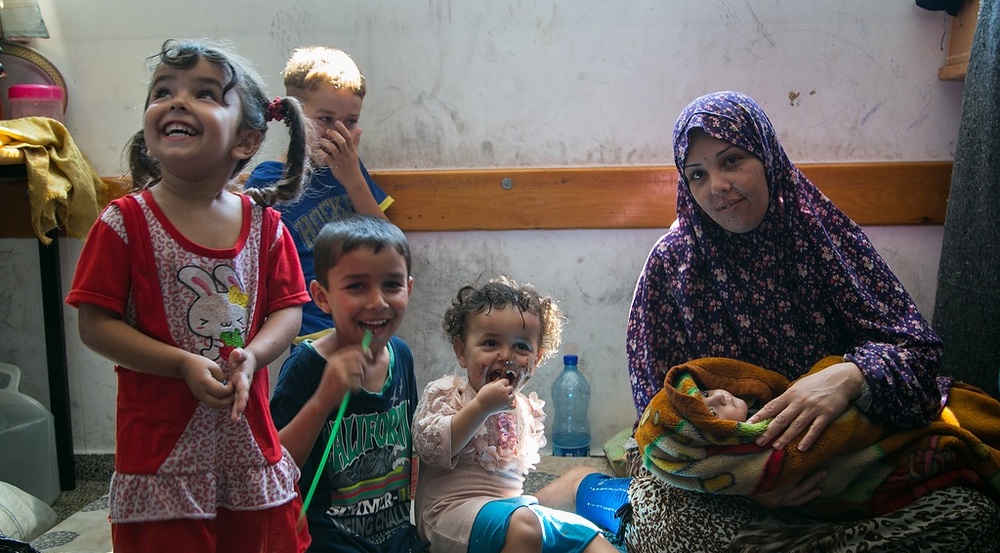 Großfamilie mit Neugeborenem in einer Notunterkunft / Copyright 2014, KNA GmbH, www.kna.de, All Rights Reserved, Andrea Krogmann Die kleine Bisan wurde am ersten Kriegstag in einer UNRWA-Schule in Gaza geboren, in die sich die Familie in Sicherheit vor den Luftangriffen gebracht hat. Die Großfamilie lebt mit 45 Personen in einem Klassenzimmer der Schule.