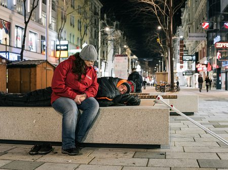 Caritas-Mitarbeiter des Kältebuses hilft Obdachlosem